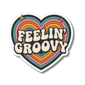 A heart-shaped sticker with retro rainbow stripes and the words 'FEELIN' GROOVY' in bold cream lettering, shown on a plain white background.