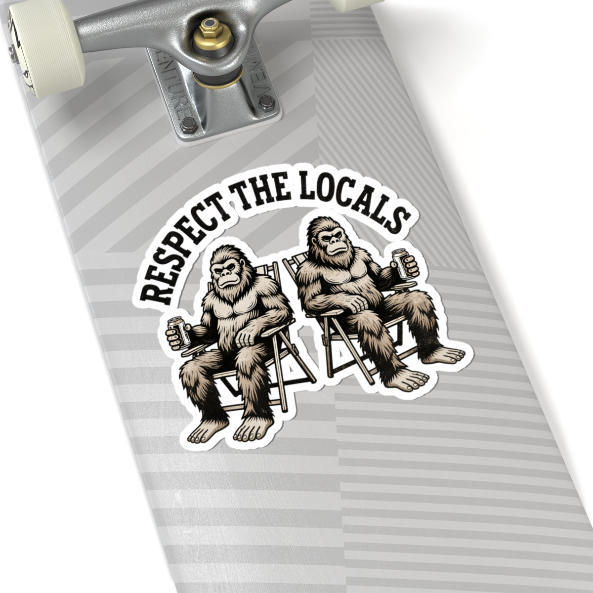 A close-up of a skateboard deck featuring a graphic sticker of two big-footed figures sitting in chairs with the text 'RESPECT THE LOCALS' above them. The skateboard has a gray and white striped pattern, and part of the silver truck and white wheel are visible at the top.