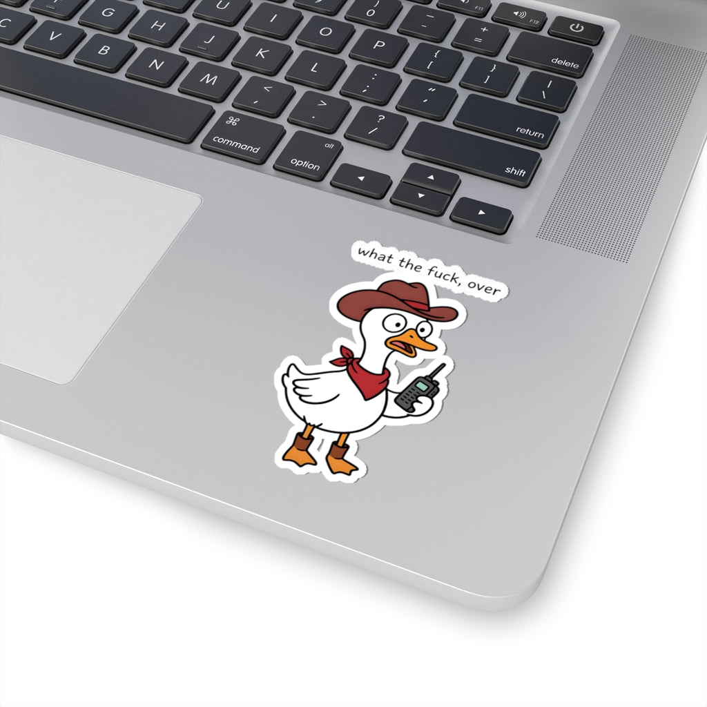 A cartoon duck sticker with the text 'what the fuck, over' is shown on the palm rest of a silver laptop. The sticker features a white duck wearing a brown cowboy hat and red bandana, holding a walkie-talkie.
