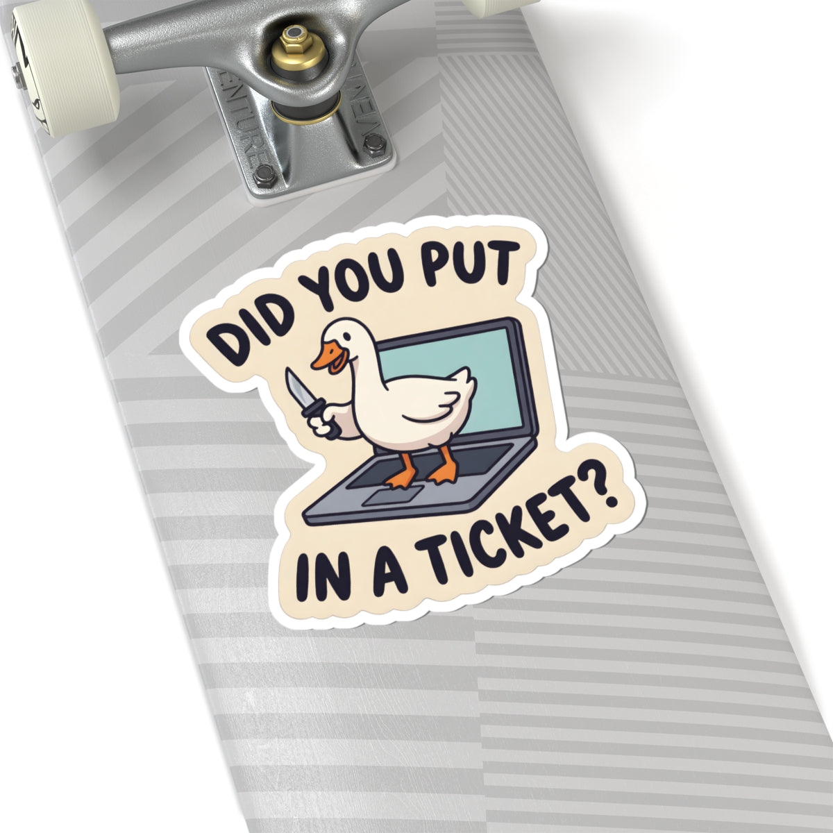 A kiss-cut sticker featuring a cartoon white duck standing on a laptop with a knife, with the text 'DID YOU PUT IN A TICKET?' in black letters on a beige background. The sticker is shown applied to the gray striped deck of a skateboard.