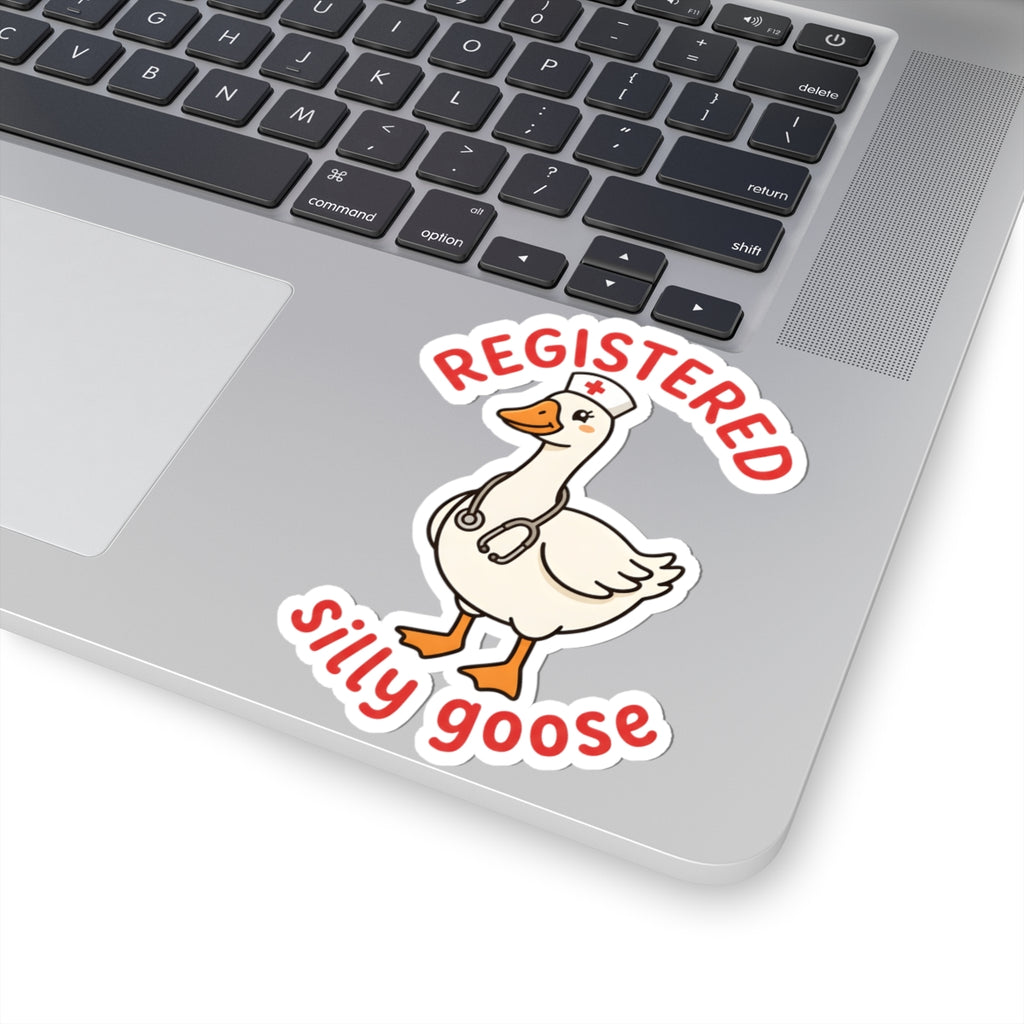 A kiss-cut vinyl sticker featuring a cartoon white goose wearing a nurse hat and stethoscope, with the words 'REGISTERED silly goose' in red lettering, shown applied to the corner of a silver laptop.