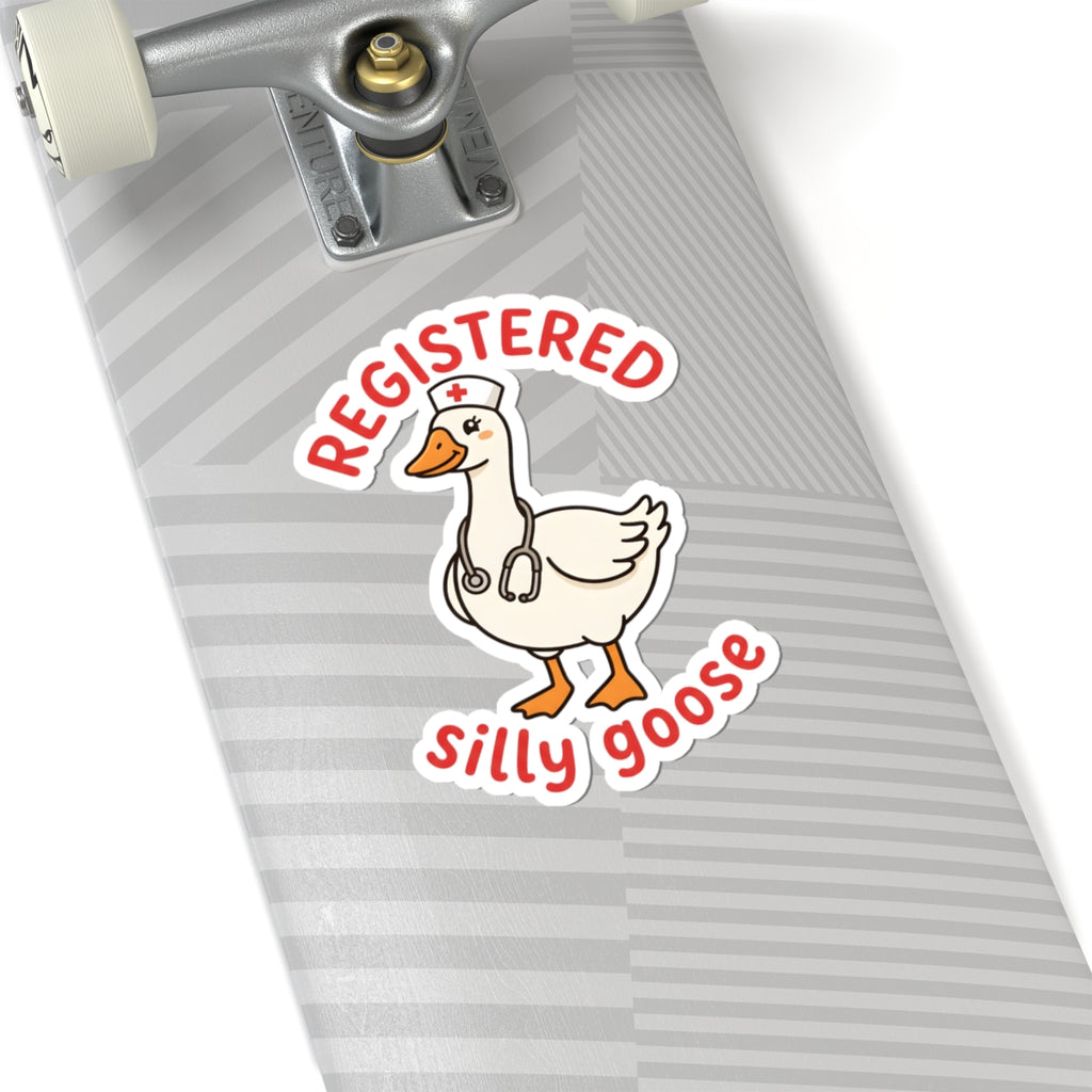 A kiss-cut sticker featuring a cartoon white goose wearing a nurse hat with a stethoscope, with the words 'REGISTERED' above and 'silly goose' below in red. The sticker is shown applied to the gray striped deck of a skateboard.
