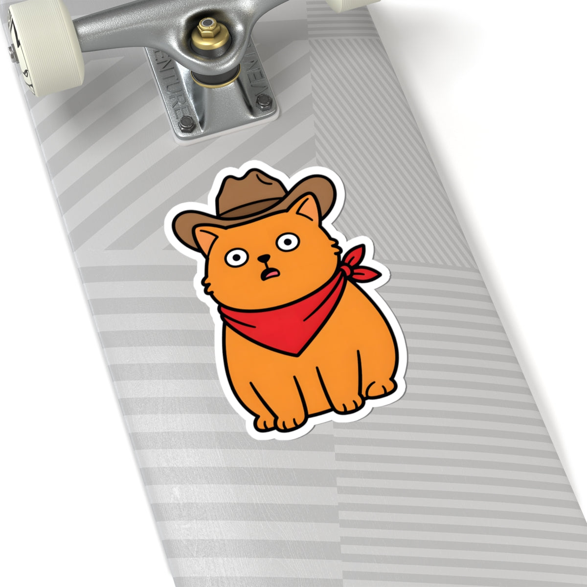 A kiss-cut sticker of a cartoon orange cat wearing a brown cowboy hat and red bandana, shown applied to the deck of a skateboard with a gray striped pattern.