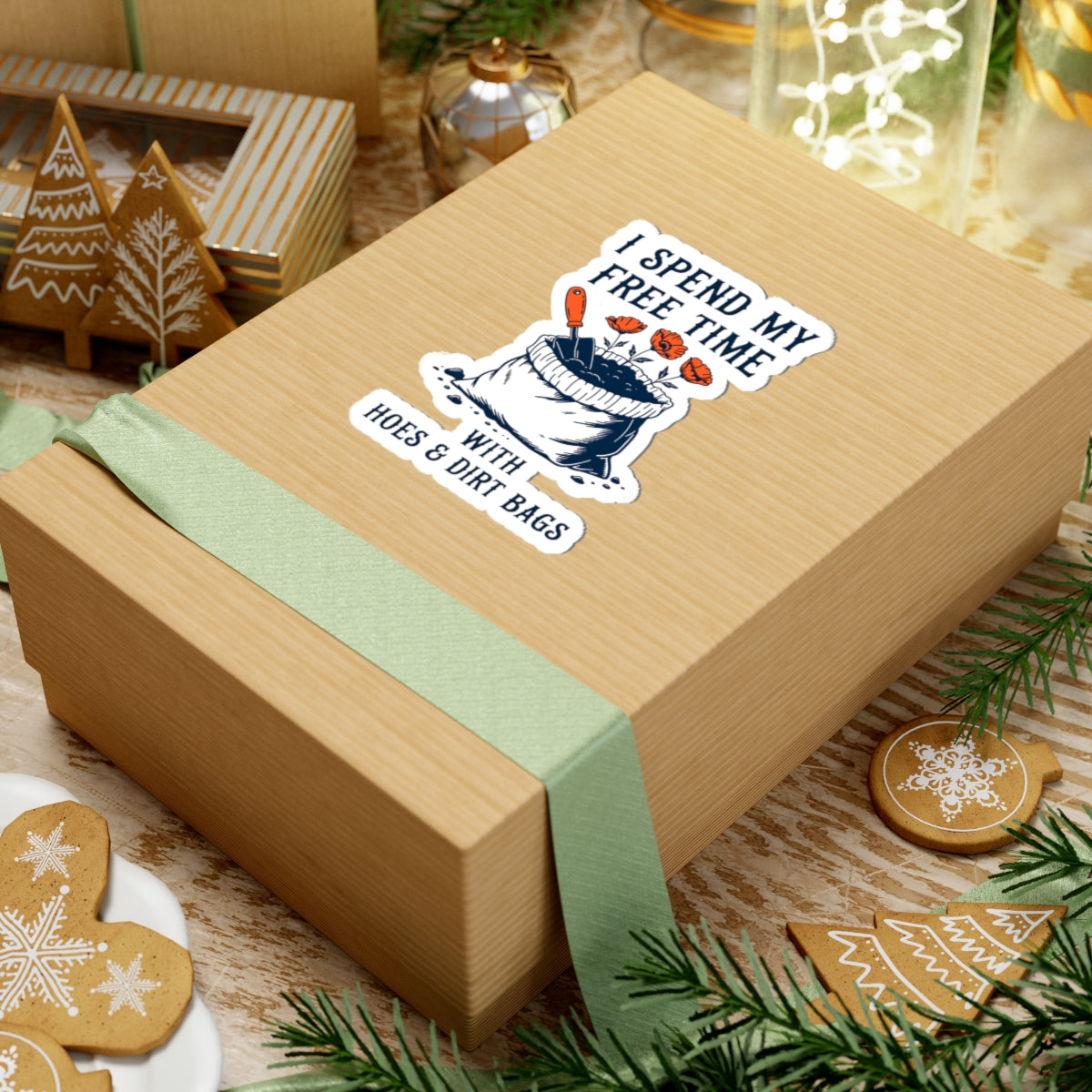 Wooden gift box with a funny garden themed sticker on a festive background with cookies and greenery.