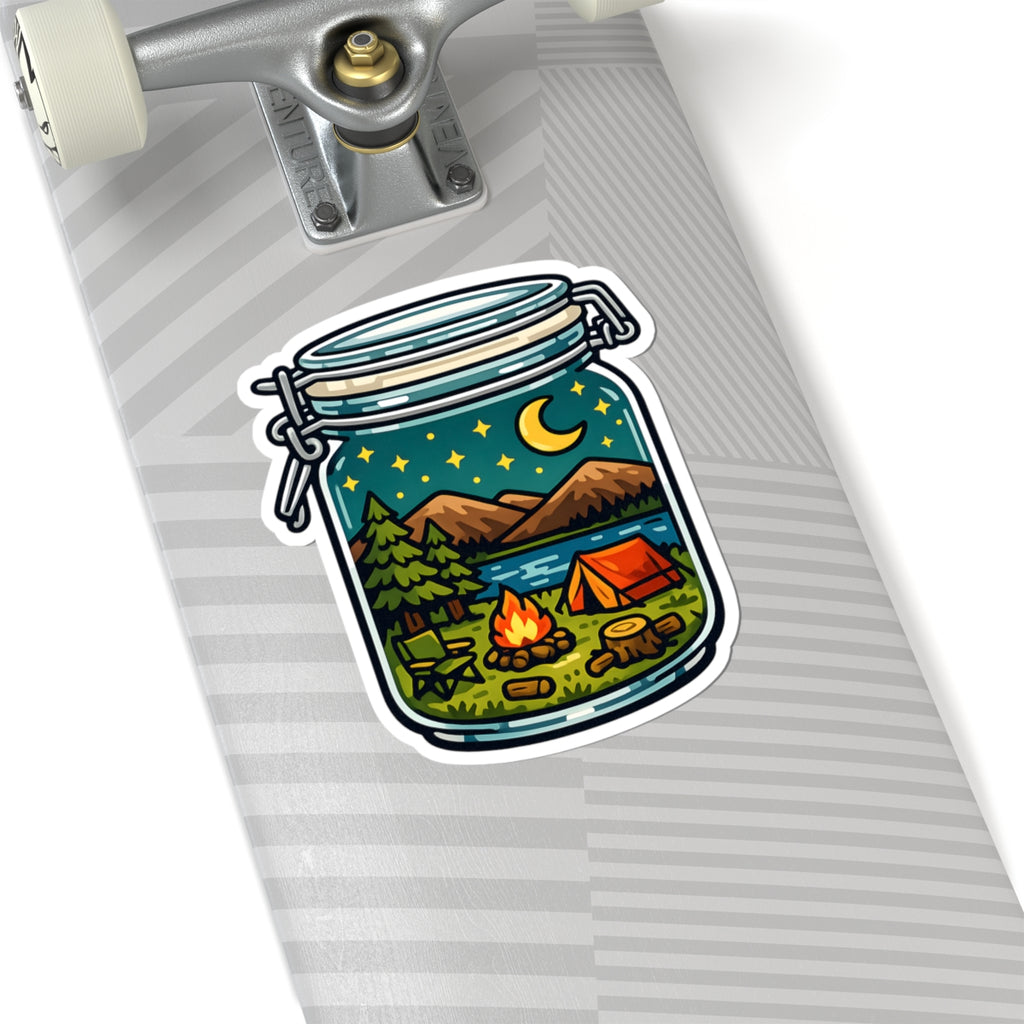 A kiss-cut sticker depicting a camping scene inside a glass jar, shown applied to the side of a silver skateboard deck.