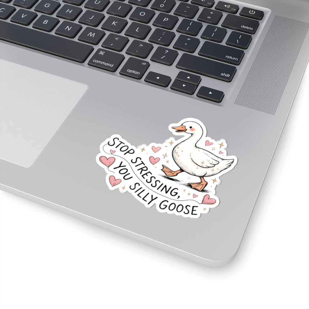 A die-cut vinyl sticker featuring a cartoon white goose with pink hearts and the text 'STOP STRESSING, YOU SILLY GOOSE' applied to the palm rest of a silver laptop.