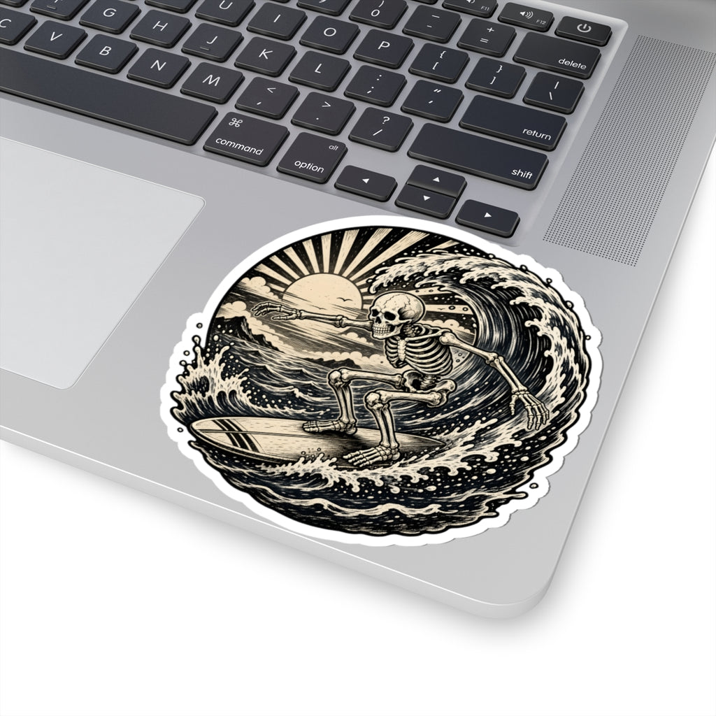 A kiss-cut vinyl sticker featuring a black and beige skeleton surfing on a wave, shown applied to the corner of a silver laptop.