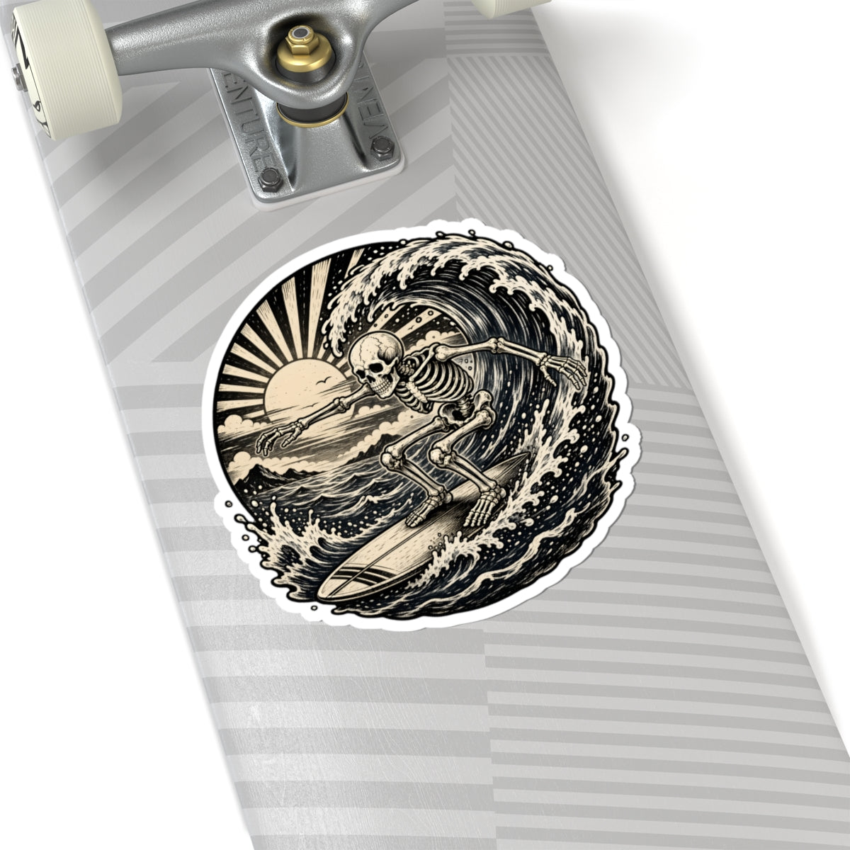 A kiss-cut sticker featuring a black and beige skeleton surfing wave, shown applied to the deck of a skateboard with a gray striped pattern.