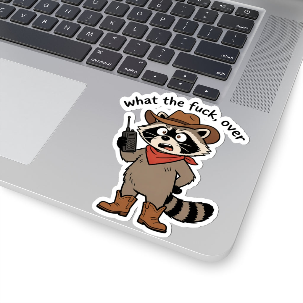 A kiss-cut vinyl sticker of a cartoon raccoon dressed as a sheriff in a cowboy hat, bandana, and boots, holding a walkie-talkie. The sticker is shown applied to the silver surface of a laptop next to the keyboard.