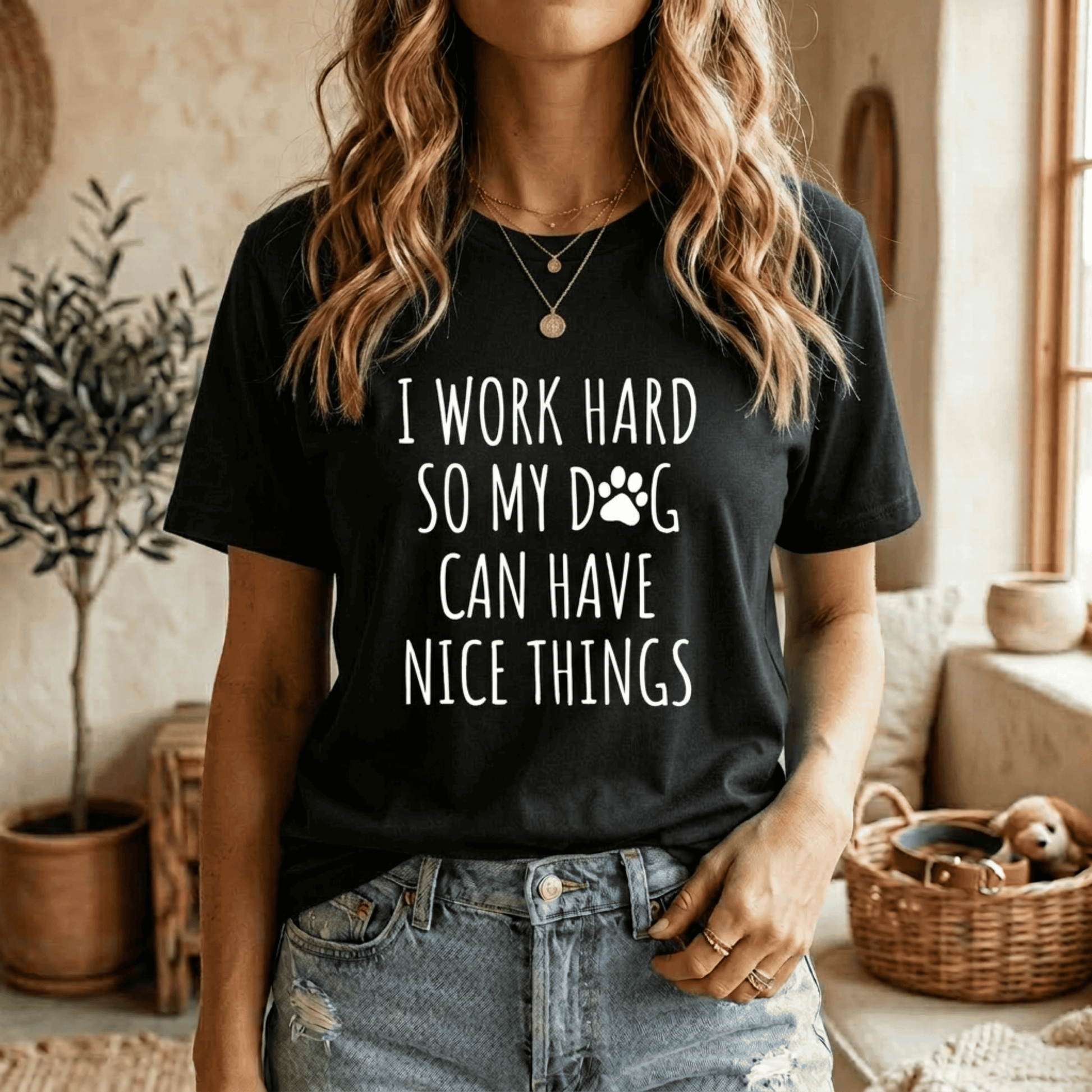 Model wearing a black graphic tee featuring white text that reads "I Work Hard So My Dog Can Have Nice Things" with a cute paw print, a perfect gift idea for a Dog Mom Mama Dog Dad Tshirt.