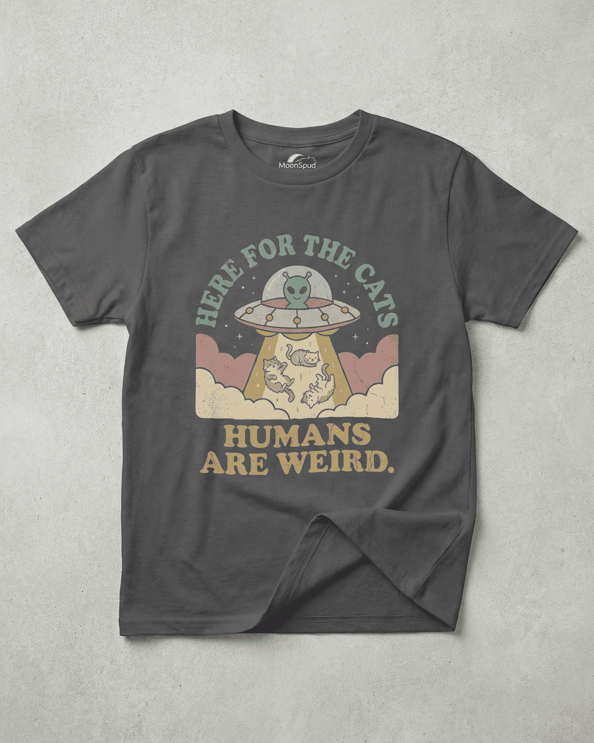 Flat lay of a charcoal Cute Kids Alien Cat T-Shirt. The vintage-style graphic features a UFO with a friendly green alien beaming up three cats with the text "Here for the Cats" and "Humans Are Weird."