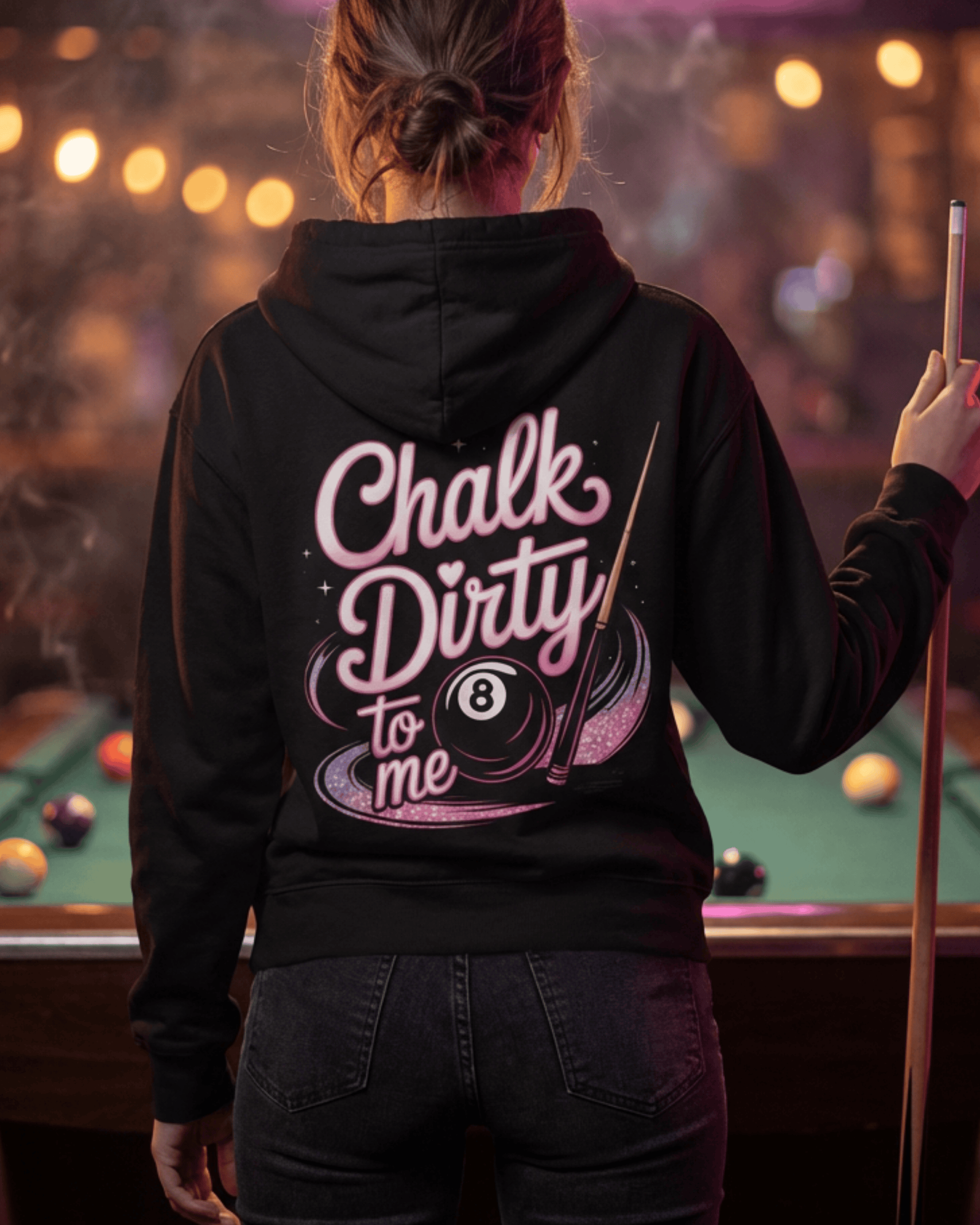 Back view of a women's billiards pool player wearing the black 'Chalk Dirty To Me' hoodie while holding a cue stick over a pool table, ready for her women's pool league game.